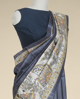 Grey+tusser+silk+saree%2C+contrast+Madhubani-style+printed+border+features+leaf+vine+%26+human+figurines+
